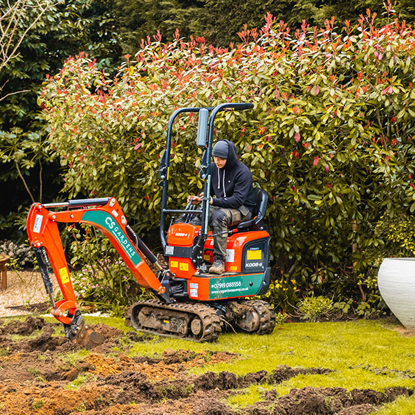 Mini digger removing turf in Esher garden for landscaping project