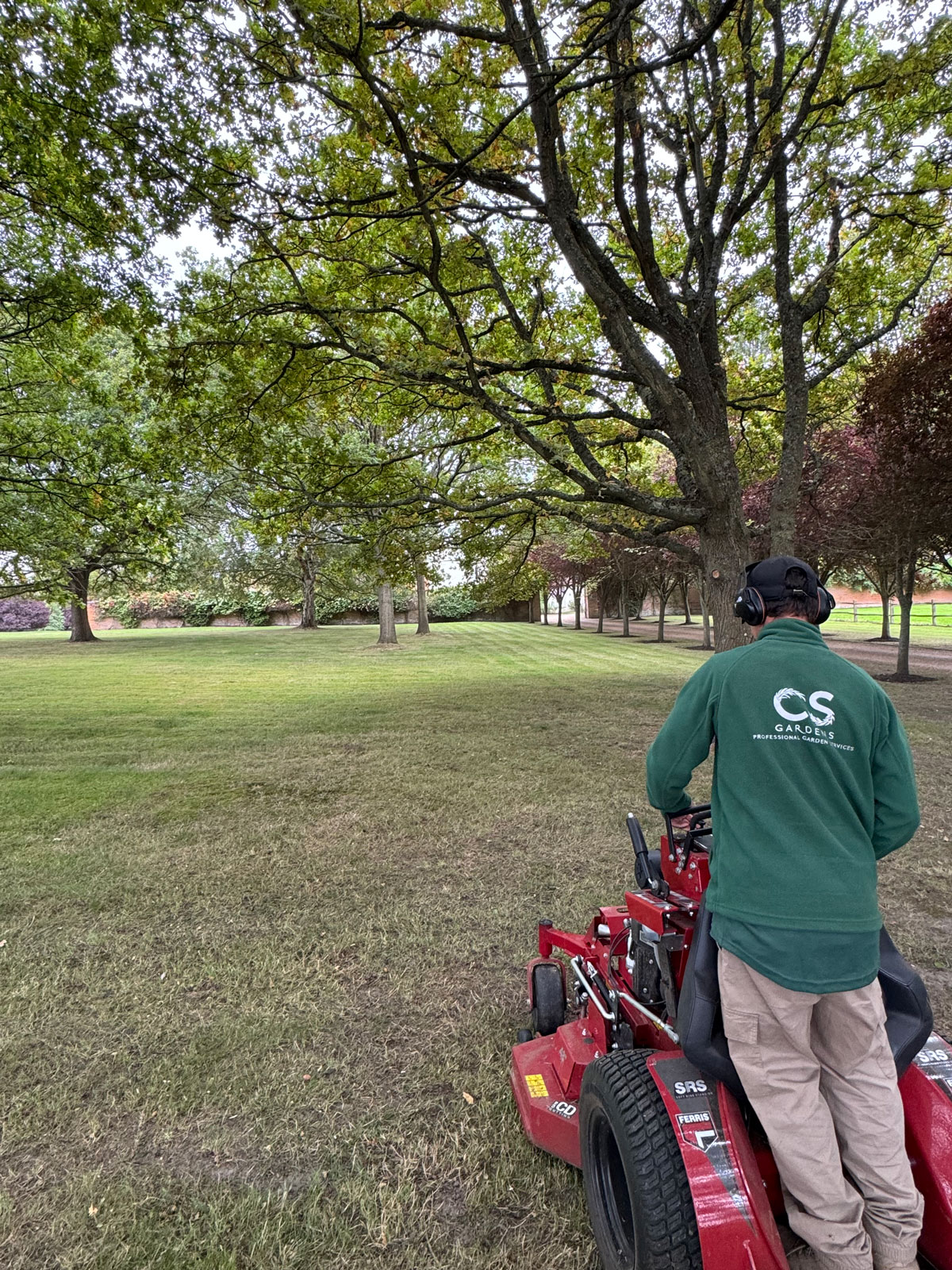 Gardener mowing Estate lawns with ride on mower