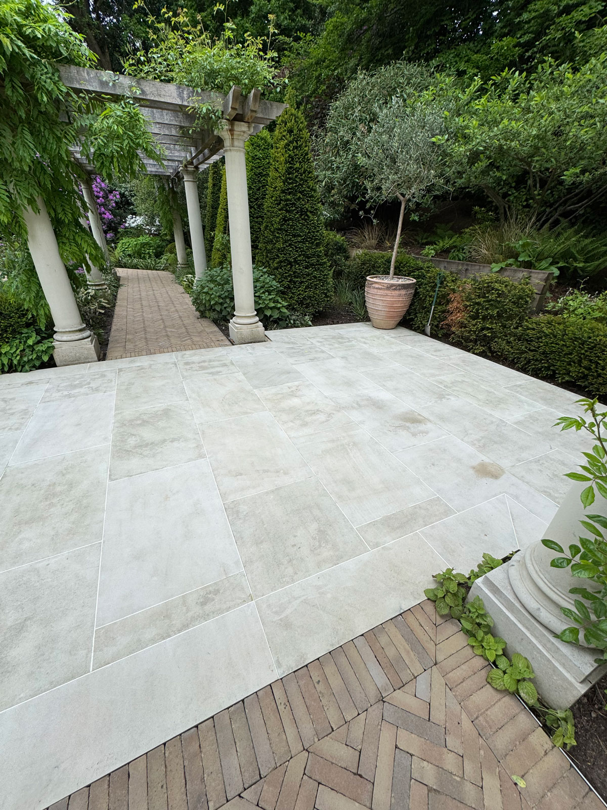 Cleaned grey tiled patio after professional jet washing in Surrey garden